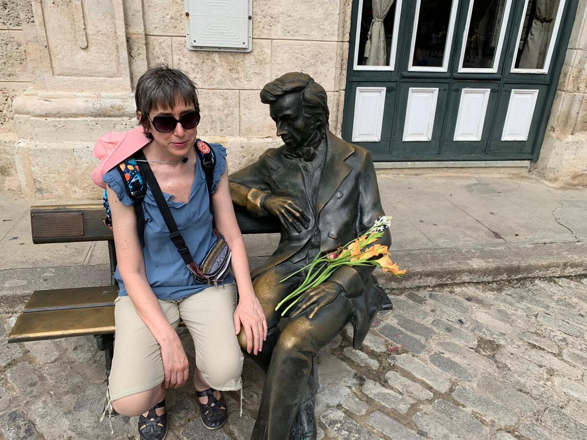 Yo sentada en un banco junto a la estatua de Chopin en La Habana.